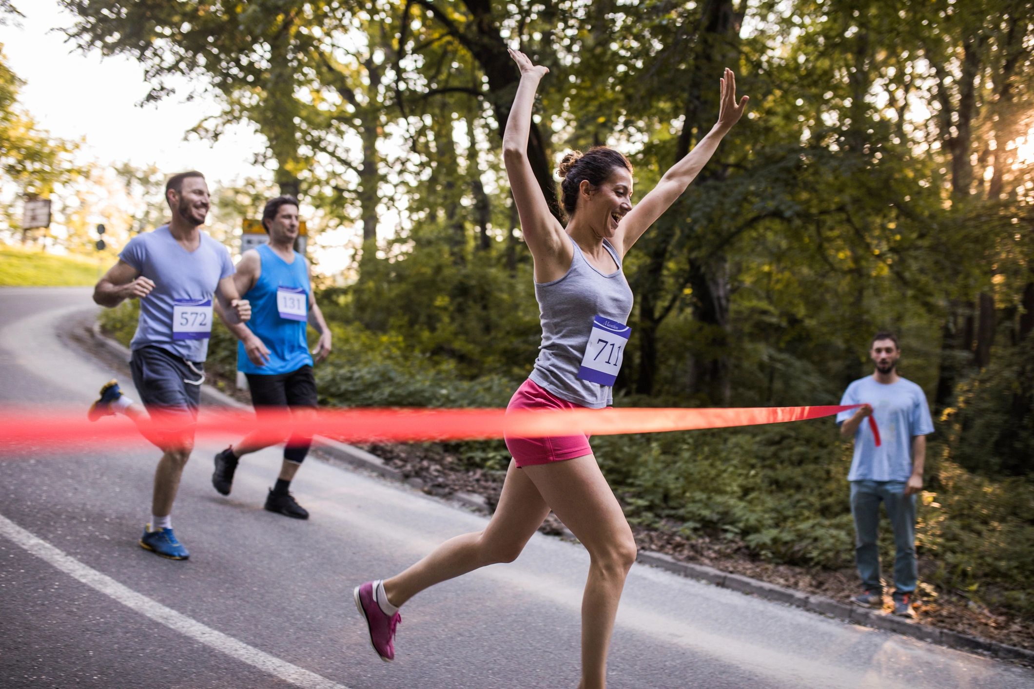 Marathon runner crossing the finish line with arms raised