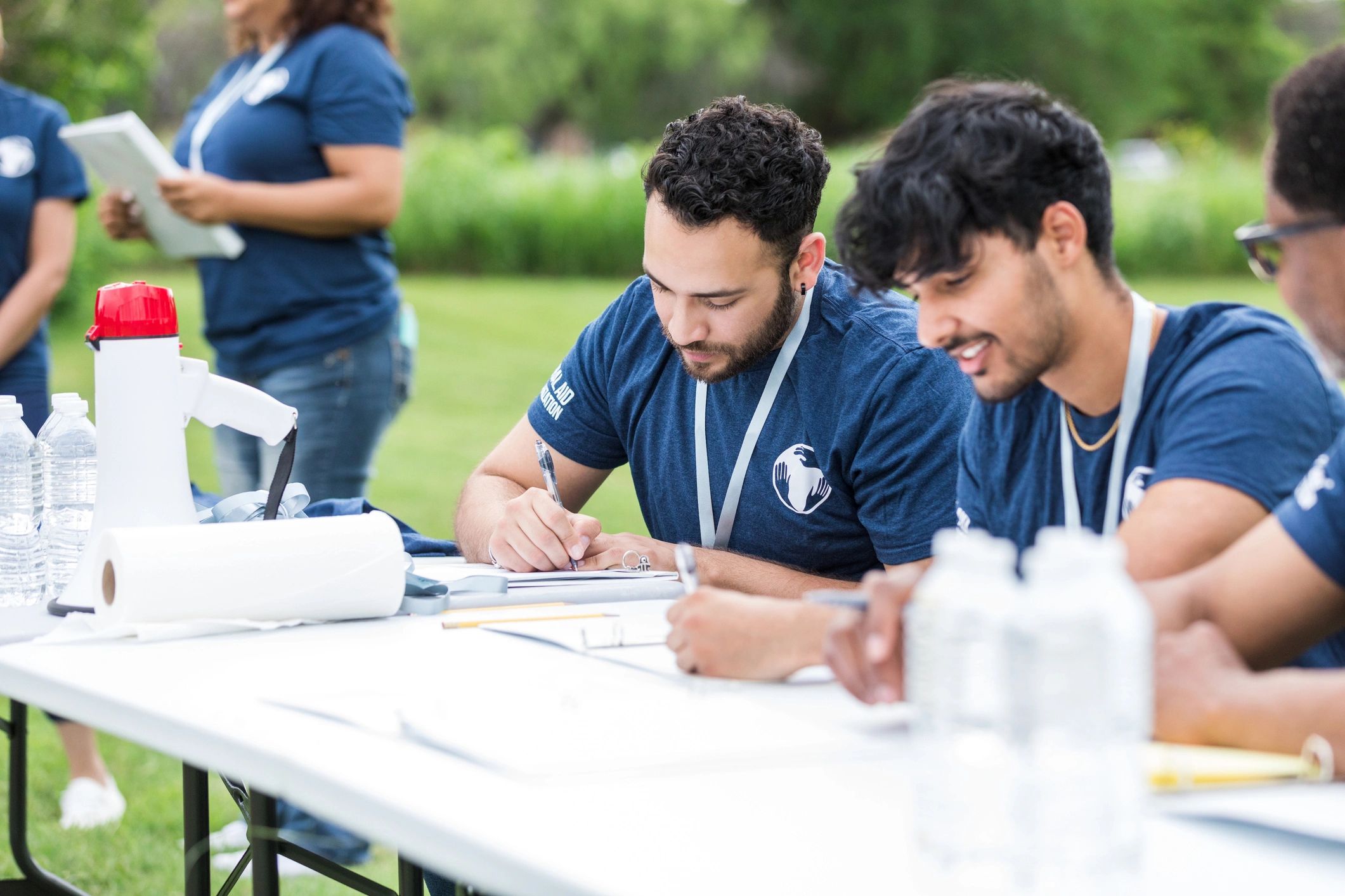 Participants at an event registration desk collecting bibs