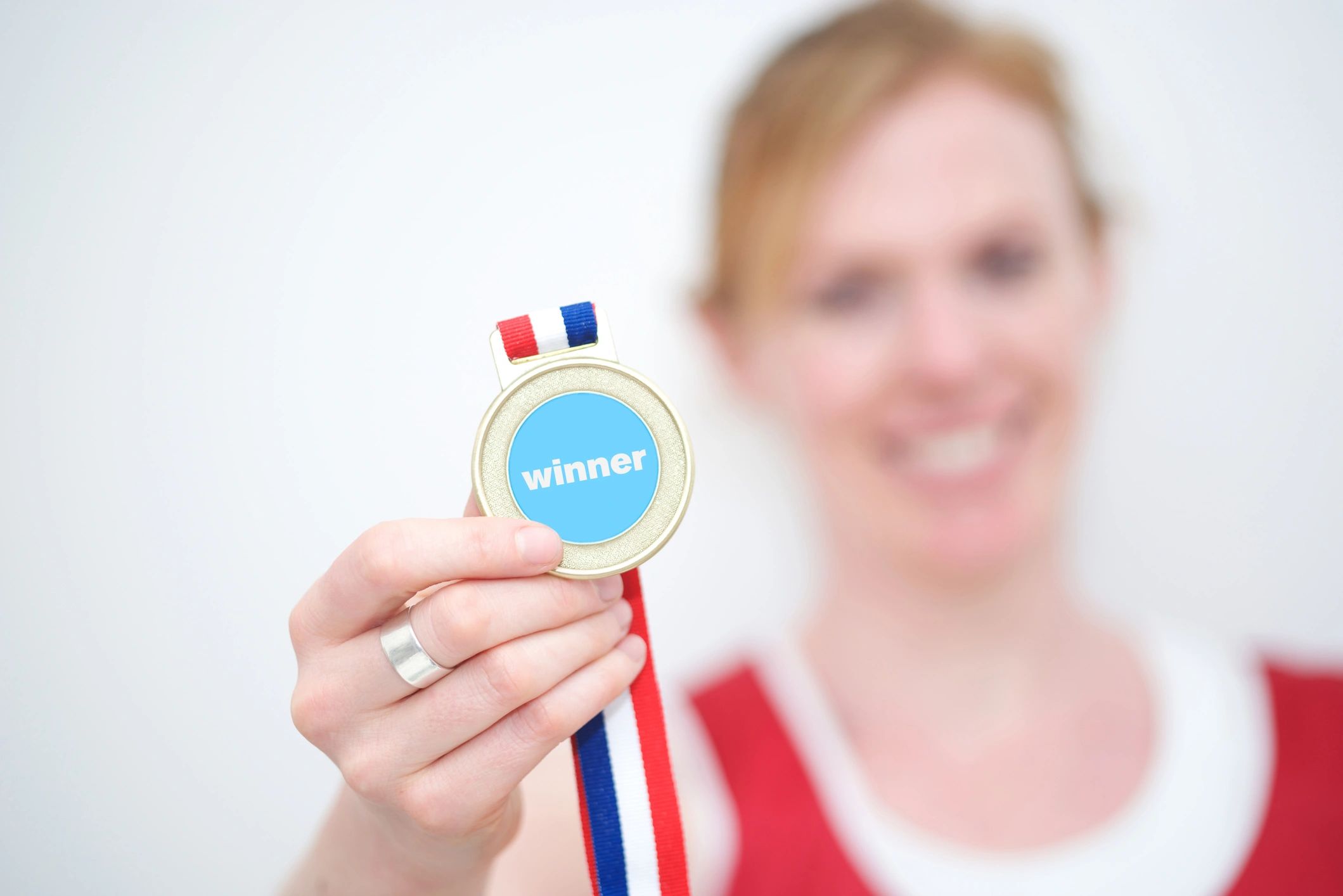 Gold marathon medal held up in a hand