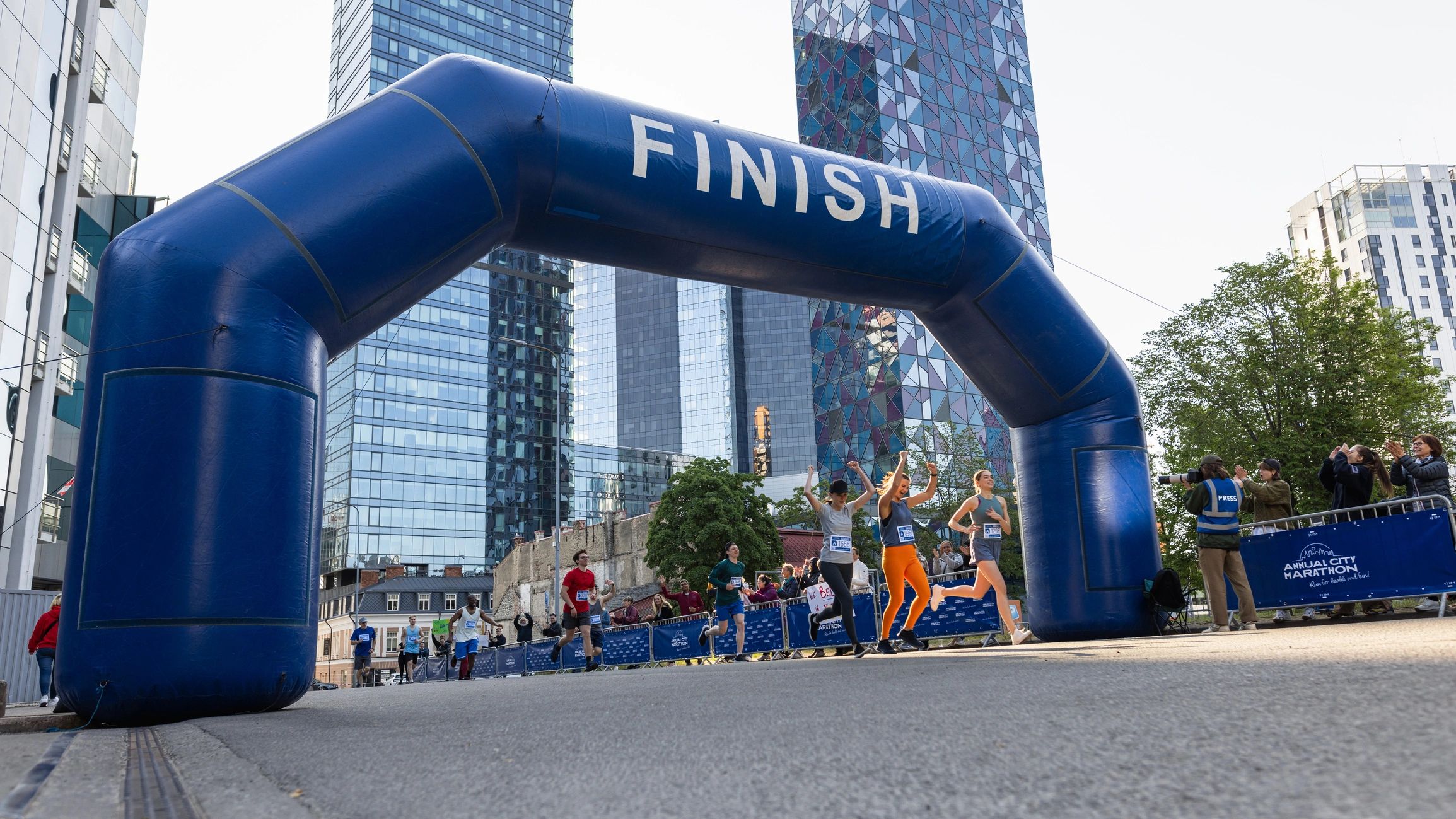 Runners celebrating as they reach the finish line at a city marathon